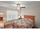 Cozy bedroom with wood-look floors, a ceiling fan, and a large bright window at 604 Juanita Ct, The Villages, FL 32159