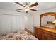 Bedroom with ceiling fan, wood-look floors, large dresser, and double closets at 604 Juanita Ct, The Villages, FL 32159