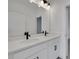 Modern bathroom featuring double vanity with white cabinetry, quartz countertop, and black hardware and faucet at 6553 Rover Way, St Cloud, FL 34771