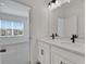 Modern bathroom with double vanity, quartz countertop, black hardware, and view into a bedroom at 6553 Rover Way, St Cloud, FL 34771