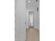 Hallway with wood-look floors leading to carpeted rooms with white trim and neutral walls at 6553 Rover Way, St Cloud, FL 34771