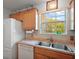 Functional kitchen area featuring stainless steel sink, tile backsplash and window view at 7650 Se 174Th Gaillard Pl, The Villages, FL 32162