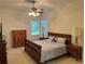 Cozy bedroom with carpet, a ceiling fan, and a neutral color scheme, showcasing comfortable living space at 8165 Bridgeport Bay Cir, Mount Dora, FL 32757