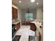 Well-lit kitchen featuring dark wood cabinets and a view of the dining room at 8165 Bridgeport Bay Cir, Mount Dora, FL 32757