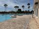 Relaxing community pool area with comfortable lounge chairs and lush palm trees at 8165 Bridgeport Bay Cir, Mount Dora, FL 32757