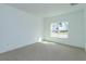 Well-lit bedroom featuring neutral carpeting and a large window bringing in natural light at 990 Fiesta Key Cir, Lady Lake, FL 32159