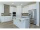 Bright kitchen with a center island, stainless steel appliances, and white cabinetry against a stylish backsplash at 990 Fiesta Key Cir, Lady Lake, FL 32159