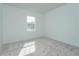 Bright bedroom featuring neutral carpet, a double-paned window, and freshly painted walls at 995 Fiesta Key Cir, Lady Lake, FL 32159