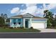 Charming single-story home featuring a 2-car garage, light blue siding and a well-manicured lawn and garden at 995 Fiesta Key Cir, Lady Lake, FL 32159