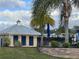 Clubhouse poolside view, featuring palm trees, lush landscaping, and comfortable lounge seating at 995 Fiesta Key Cir, Lady Lake, FL 32159