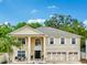 Two-story home with a three-car garage, columns, and large front windows, creating a bright and welcoming facade at 1454 Sterns Dr, Leesburg, FL 34748