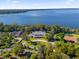 Expansive aerial view showcasing the luxurious lakeside estate surrounded by lush greenery at 15749 Acorn Cir, Tavares, FL 32778