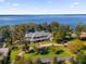 Aerial view of waterfront estate with manicured lawn, mature trees, circular driveway and private dock at 15749 Acorn Cir, Tavares, FL 32778
