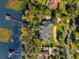 Overhead aerial view of a lakeside estate with a private dock and lush landscaping at 15749 Acorn Cir, Tavares, FL 32778