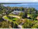 Stunning aerial view of a grand estate nestled on the shores of a serene lake at 15749 Acorn Cir, Tavares, FL 32778