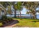 Beautiful waterfront property with lush lawn, mature trees and private dock with lake access at 15749 Acorn Cir, Tavares, FL 32778