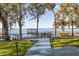 Lush backyard features a walkway and patio leading to a private dock with gazebo on the water at 15749 Acorn Cir, Tavares, FL 32778
