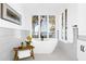 Elegant bathroom featuring a freestanding tub, waterfront view, and natural light at 15749 Acorn Cir, Tavares, FL 32778
