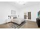 Cozy bedroom featuring neutral bedding, modern nightstands, and patio doors leading to the backyard at 15749 Acorn Cir, Tavares, FL 32778