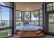 A screened patio dining area featuring brick stairs, a patterned rug, and views of the lake and dock at 15749 Acorn Cir, Tavares, FL 32778