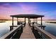 Private dock with sheltered seating providing a serene spot to relax and take in the beautiful lake scenery at 15749 Acorn Cir, Tavares, FL 32778
