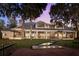 Expansive home exterior showcases large windows, a lush lawn, and a charming pathway leading to outdoor lake access at 15749 Acorn Cir, Tavares, FL 32778