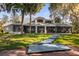 Expansive home with a gray roof, screened in porch, a lush lawn, a long lighted walkway and mature trees at 15749 Acorn Cir, Tavares, FL 32778