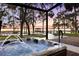 Hot tub with a view of the lake and dock at sunset, creating a serene and inviting outdoor space at 15749 Acorn Cir, Tavares, FL 32778