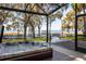 Enclosed patio featuring a hot tub overlooking tranquil lake waters and lush landscaping at 15749 Acorn Cir, Tavares, FL 32778