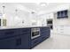Kitchen island features navy cabinets, stainless steel microwave, and quartz countertops at 15749 Acorn Cir, Tavares, FL 32778