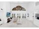 Bright, airy living room with a high ceiling, a fireplace, and a view of the lake at 15749 Acorn Cir, Tavares, FL 32778