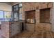 An outdoor kitchen featuring brick construction, granite countertop, a stainless grill, and mini-refrigerator at 15749 Acorn Cir, Tavares, FL 32778