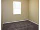 This bedroom has tan walls, gray carpet and a window with white blinds at 2572 Limerick Cir, Grand Island, FL 32735
