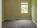 Bedroom featuring a window with white blinds, carpet, and a neutral colored wall at 2572 Limerick Cir, Grand Island, FL 32735