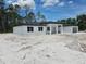Contemporary home with a black roof, white exterior and an attached garage at 40327 Royal Trails Rd, Eustis, FL 32736