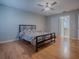 Comfortable bedroom with ensuite bathroom access features wood floors and a ceiling fan at 3360 Richmond Dr, The Villages, FL 32162