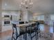 The dining room features a six-chair table with a modern chandelier, and an open layout to the kitchen and living room at 3360 Richmond Dr, The Villages, FL 32162