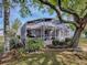 A tranquil backyard view with a screened-in patio and mature trees offering ample shade at 3360 Richmond Dr, The Villages, FL 32162