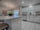 Open concept kitchen with island, sleek appliances, tiled floors, and abundant natural light at 3360 Richmond Dr, The Villages, FL 32162