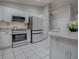 Bright kitchen is equipped with stainless steel appliances, white cabinets, and tiled backsplash at 3360 Richmond Dr, The Villages, FL 32162