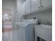 Laundry room featuring front load washer and dryer, utility sink, tile flooring, and white cabinetry at 3360 Richmond Dr, The Villages, FL 32162