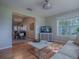 Living room view showcasing hardwood floors, adjacent dining area, and a decorative entertainment center at 3360 Richmond Dr, The Villages, FL 32162