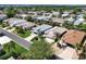 Aerial view showcasing a vibrant neighborhood, lush greenery, and a serene lake backdrop at 5441 Sea Leopard St, Tavares, FL 32778