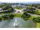 Aerial view of a pond with a fountain and a community center with cabanas and lush green landscaping at 5441 Sea Leopard St, Tavares, FL 32778