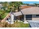 Aerial view of home showcasing a patio, lush landscaping, a retaining wall, and a striped awning at 5441 Sea Leopard St, Tavares, FL 32778