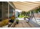 Relaxing patio with a retractable awning, a porch swing, and lush potted plants at 5441 Sea Leopard St, Tavares, FL 32778
