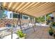 Covered patio with a porch swing, BBQ, potted plants, and white rock ground cover at 5441 Sea Leopard St, Tavares, FL 32778