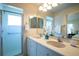 Bathroom featuring double sinks, a shower, and neutral decor at 5441 Sea Leopard St, Tavares, FL 32778