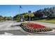 Community entrance featuring colorful landscaping and an American flag waving in the breeze on a bright, sunny day at 5441 Sea Leopard St, Tavares, FL 32778