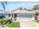 Inviting single-Gathering home features a large two-car garage, green lawn, and manicured landscaping at 5441 Sea Leopard St, Tavares, FL 32778